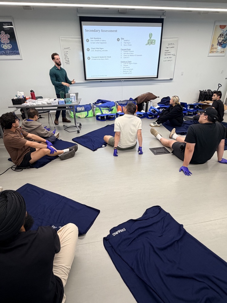Alder students practicing secondary assessment on the classroom floor at Langara College